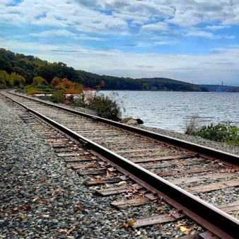 Las vías del ferrocarril cerca del agua se extienden a lo lejos en el Parque Estatal Stoddard Hill